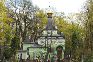 Часовня Святой Блаженной Ксении Петербургской затерялась среди деревьев кладбища